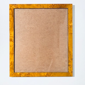 Könnte beinhalten: Ein goldener Bilderrahmen mit einem braunen Karton-Einsatz. Der Rahmen hat eine Holzmaserung.