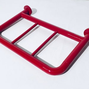 Puede incluir: Barra de agarre de metal roja con tres barras horizontales para apoyo. La barra de agarre está diseñada para su uso en un baño o ducha.