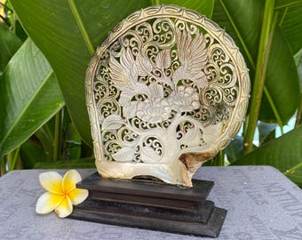 Figura de colibrí tallada en concha de nácar con soporte.
