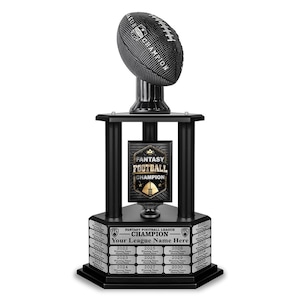 May include: A black and gold fantasy football trophy with a football on top. The trophy has a plaque that says "Fantasy Football Champion" and a base with years from 2017 to 2035.