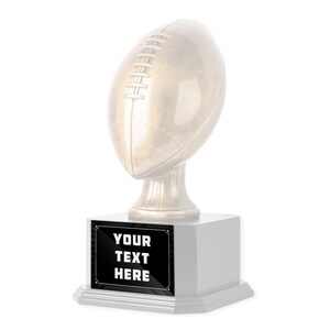 May include: A gold-colored football trophy with a black plaque that reads "YOUR TEXT HERE".