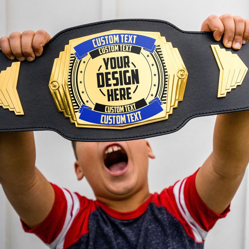 May include: A black and gold championship belt with a blue ribbon and the text "CUSTOM TEXT CUSTOM TEXT YOUR DESIGN HERE CUSTOM TEXT CUSTOM TEXT".