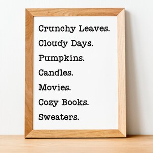 May include: A framed print with a list of autumnal words: Crunchy Leaves, Cloudy Days, Pumpkins, Candles, Movies, Cozy Books, and Sweaters.