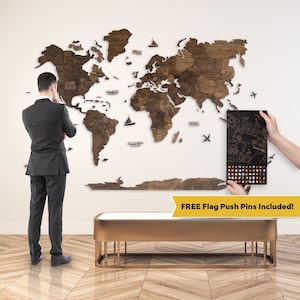 May include: A large, multi-piece wooden world map wall art installation featuring dark brown wood grain, engraved country names, and ocean labels. The set includes decorative wooden ship and airplane icons, along with a black box of colorful flag push pins.