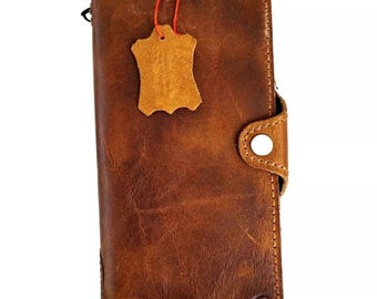 Puede incluir: Una cartera de cuero marrón con cierre de solapa y una pequeña etiqueta de cuero. La cartera tiene un aspecto desgastado y está hecha de cuero de alta calidad.