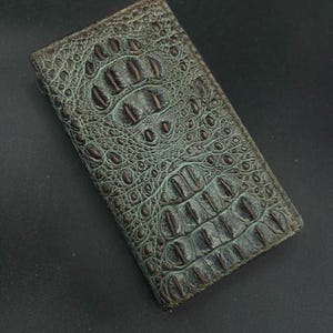 May include: A green alligator skin wallet with a brown embossed pattern.