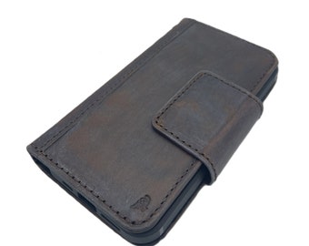 Puede incluir: Una funda de teléfono de cuero marrón con una solapa que se pliega sobre la pantalla. La funda tiene un borde cosido y un pequeño logotipo en la parte delantera.