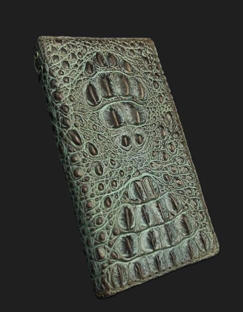 May include: A green alligator skin wallet with a textured pattern.