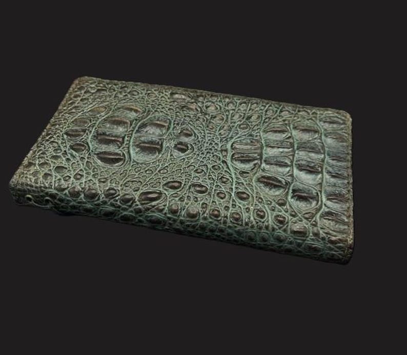 May include: A green alligator skin wallet with a textured surface.