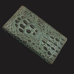 May include: A green alligator skin wallet with a textured pattern.