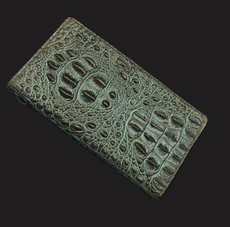 May include: A green alligator skin wallet with a textured pattern.