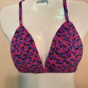 May include: A crocheted triangle bra top in shades of pink, purple, and blue.