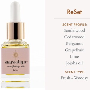 May include: A glass bottle of stars align manifesting oil labeled "ReSet" with a gold cap and dropper. The scent profile is sandalwood, cedarwood, bergamot, grapefruit, lime, and jojoba oil. The scent type is fresh and woodsy.