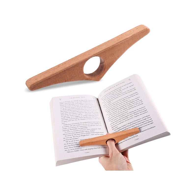 May include: A wooden book page holder with a hole for a finger. The holder is designed to keep a book open while reading. The holder is made of natural wood and has a smooth finish.