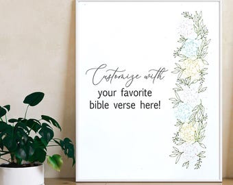 May include: A white framed wall art print featuring the black text "Customize with your favorite bible verse here!" on the left side and a vertical floral border of green leaves and light blue and yellow flowers on the right side.