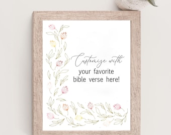 May include: A light wood-toned frame containing a white print with a floral border of delicate pink, yellow, and green line-art flowers. The text reads: Customize with your favorite bible verse here! The frame has a textured, natural wood finish.