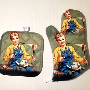 May include: A quilted pot holder and oven mitt set. The set features a vintage illustration of a woman in a yellow shirt and blue apron using a torch on a piece of bread. The background is a muted green color.