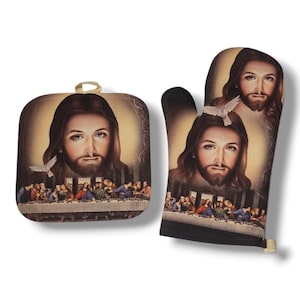 May include: A square beige pot holder and an oven mitt featuring a religious image. The image depicts a portrait of Jesus with a dove and a scene of the Last Supper. The pot holder has a gold loop for hanging.