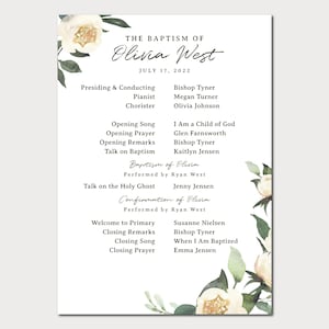 May include: A white and green floral design with the text "THE BAPTISM OF Olivia West JULY 17, 2022" and a list of names and titles for the ceremony.