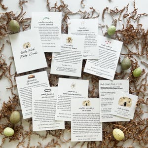 May include: A collection of white study cards with religious themes, featuring text and illustrations. The cards are scattered on a bed of brown paper, with decorative speckled eggs. The cards are titled "Holy Week Study Cards".