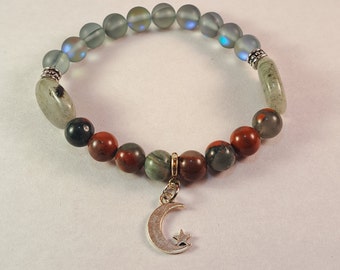 May include: A beaded bracelet with a moon and star charm. The bracelet features iridescent gray beads, red and green jasper beads, and silver accents.