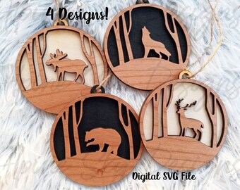 May include: Four wooden ornaments with a black and white forest scene and a cutout of a moose, wolf, deer, and bear. The ornaments are hanging from a string and have a "Digital SVG File" label.