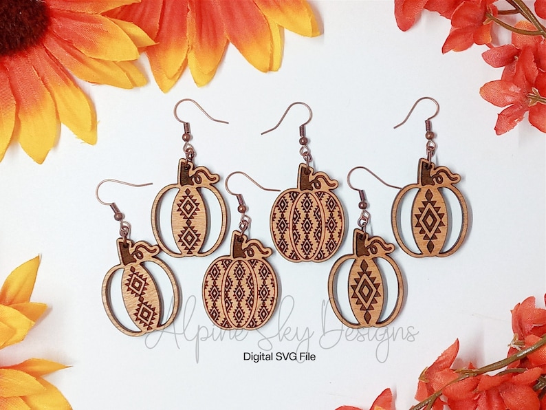 Peut inclure: Cinq paires de boucles d'oreilles en bois en forme de citrouille avec un motif g&eacute;om&eacute;trique. Les boucles d'oreilles sont brunes avec un crochet de couleur cuivre.