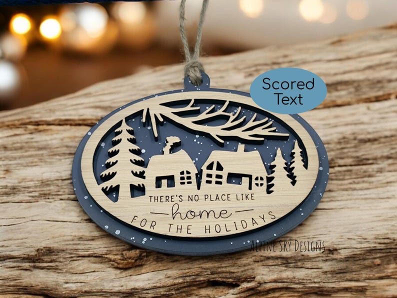 May include: A wooden Christmas ornament with a blue background and white glitter. The ornament features a silhouette of a house with trees and the text "There's no place like home for the holidays".