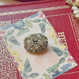 Broche ovalado plateado de 3 cm con racimo de diamantes de imitación de estilo vintage. Presentado en caja de regalo.