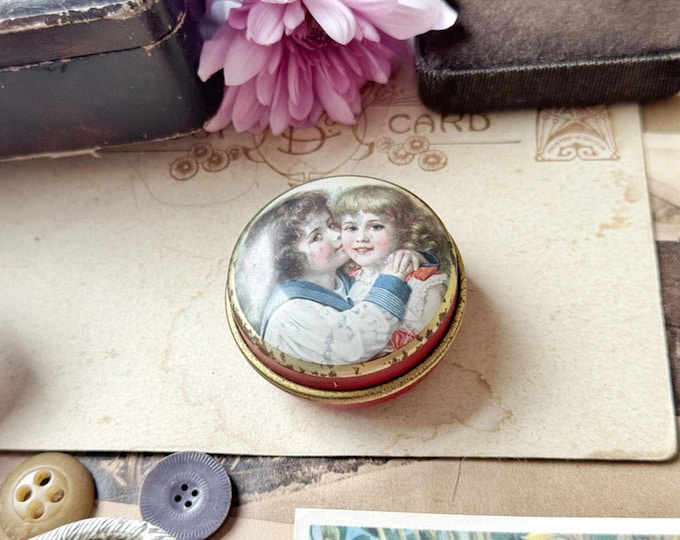 Vintage red and gold cosmetic or pill pot with romantic Victorian-style lid art