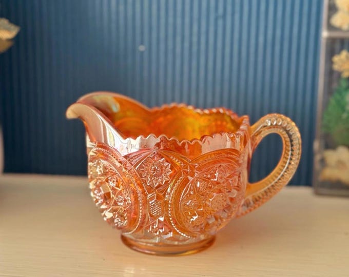 Vintage marigold carnival glass creamer with bold medallion pattern