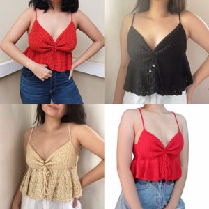 Puede incluir: Tres tops de crochet en diferentes colores: rojo, negro y beige. Cada top tiene un escote en V, tirantes ajustables y un dobladillo con volantes.