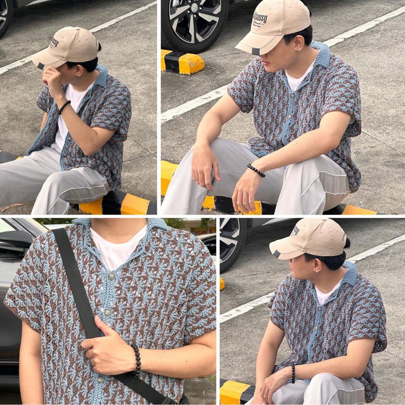 May include: A beige baseball cap with the word "assy" on the front. The person is wearing a short-sleeved, patterned shirt in shades of blue and brown, paired with gray pants. A black bracelet is visible on the wrist.