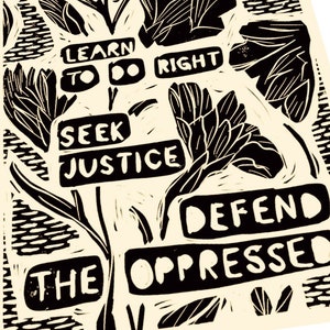 May include: Black and white linocut print featuring stylised flowers and the text "Learn to do right, Seek Justice, Defend the Oppressed".