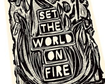 Puede incluir: Grabado en madera en blanco y negro con el texto "SET THE WORLD ON FIRE" en una fuente estilizada. El texto está rodeado por un diseño en blanco y negro de llamas y hojas.