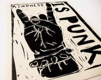 Puede incluir: Impresión en blanco y negro de una mano haciendo el signo de la paz con el texto "KINDNESS IS PUNK" impreso verticalmente en el lado derecho de la imagen.