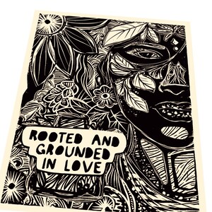 Op de afbeelding: Zwart-witte linosnede van een gezicht omringd door bloem- en bladmotieven. De tekst "Rooted and Grounded in Love" staat in een spraakballon onderaan de print.
