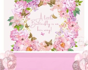 Könnte beinhalten: Ein rosafarbener und grüner Blumenkranz mit goldenen Glitzer-Schmetterlingen und dem Text "A little Butterfly is on her way!" Der Kranz befindet sich auf einem hellrosa Hintergrund.