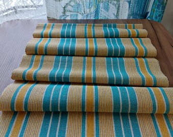 May include: A folded table runner with alternating stripes of teal blue and mustard yellow.