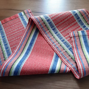 May include: Red, white, blue, and green striped table runner with a woven texture.