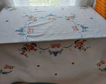May include: White tablecloth with embroidered floral designs in shades of pink, blue, and green. The tablecloth features a central diamond pattern and a border of floral motifs.