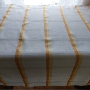 May include: White throw blanket with orange and yellow stripes.
