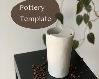 May include: White ceramic pottery vase with a unique, asymmetrical design. The vase is sitting on a black table with coffee beans scattered around it.