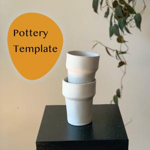Puede incluir: Dos macetas de cerámica azul claro apiladas, con una banda beige. Las macetas están sobre una superficie negra, con el texto "Pottery Template" en negro sobre un óvalo naranja en el fondo. Se ven hojas verdes.