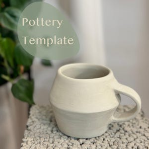 May include: A white ceramic mug with a rounded body and a handle. The mug has a textured surface and a slightly flared rim.