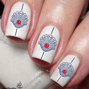 May include: White nail polish with blue and red seashell nail art designs.