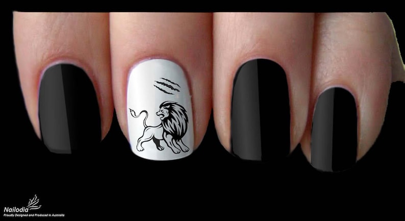 May include: Close-up of four fingernails with black and white nail art. One fingernail has a black lion design with claw marks on a white background.