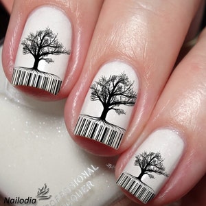 Puede incluir: Esmalte de uñas blanco con diseños de árboles en blanco y negro y códigos de barras en cada uña.