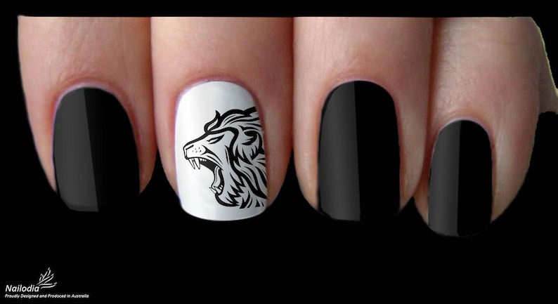 May include: Black and white nail art decals featuring a roaring lion head design. The decals are applied to a white nail polish base with the remaining nails painted black.
