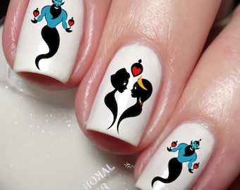 May include: White nail polish with a black and blue genie silhouette holding red hearts. The genie is from the movie Aladdin. The nail polish is on a finger.